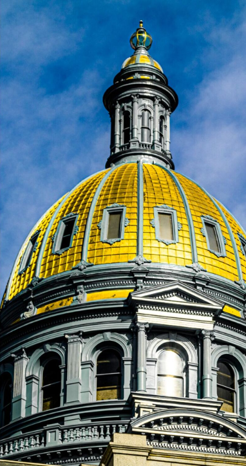 The gold-leafed dome of the Colorado State Capitol against a blue sky
